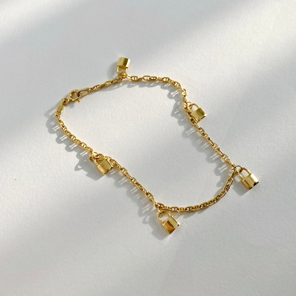 Simple yet stylish bracelet with five golden padlocks.  
